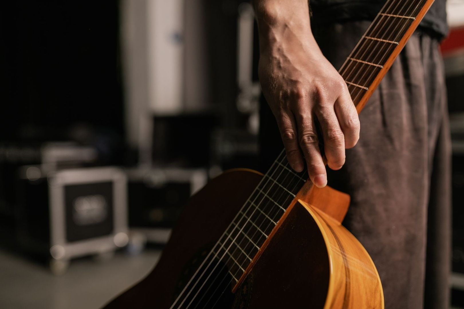 Nahaufnahme einer Hand an einer akustischen Gitarre auf der Bühne