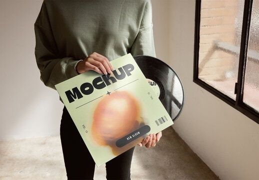 Person hält ein Vinylalbum mit Plattenschallplatte in den Händen